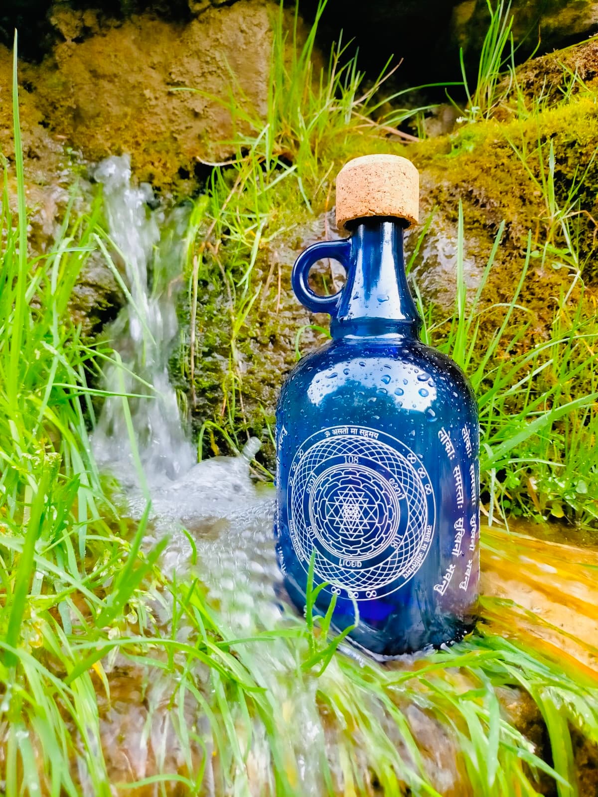 Botella Devi en un manantial, con el grabado de la Flor de la Vida